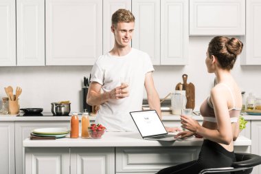 dizüstü yüklü google sayfası ile kullanma ve erkek mutfakta bakarak kız