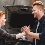 Father and son holding hands after repairing car