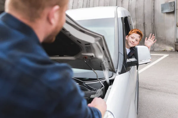 Vater Repariert Auto Mit Offener Motorhaube Sohn Winkt — kostenloses Stockfoto