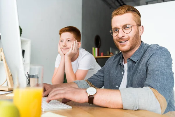 Sorrindo Pai Filho Sentados Mesa Com Computador Casa — Fotografia de Stock