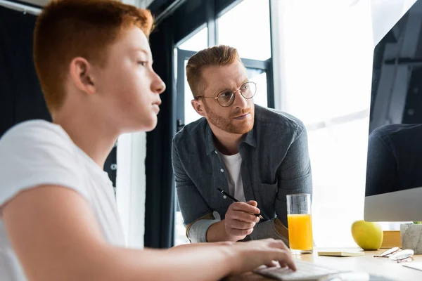 Père Regardant Son Fils Utilisant Ordinateur Maison — Photo gratuite