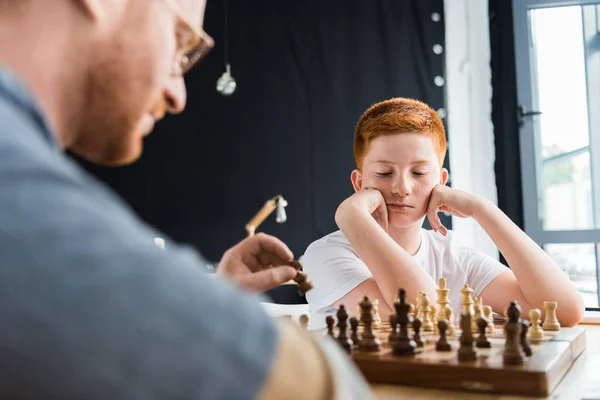 Σκεπτικός Γιος Που Βλέπει Την Σκακιέρα Στο Σπίτι — Φωτογραφία Αρχείου