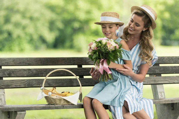 Sonrientes Madre Hija Con Frutas Canasta Mimbre Ramo Floral Sentado — Foto de stock gratis