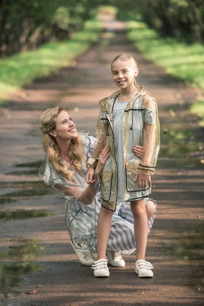 Happy Mother Daughter Posing Transparent Raincoats Wet Road — Free Stock Photo