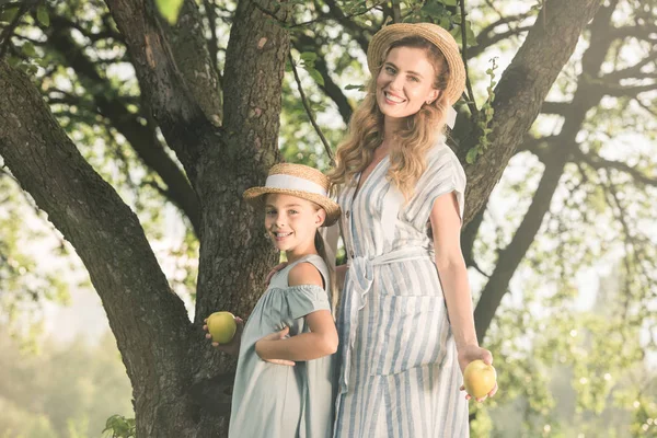 Blonde Smiling Mother Daughter Straw Hats Holding Appples Garden — Free Stock Photo