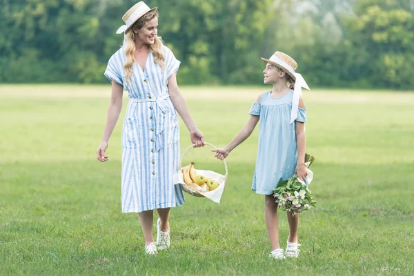 Bela Mãe Filha Segurando Cesta Vime Com Frutas Andando Gramado — Fotografia de Stock