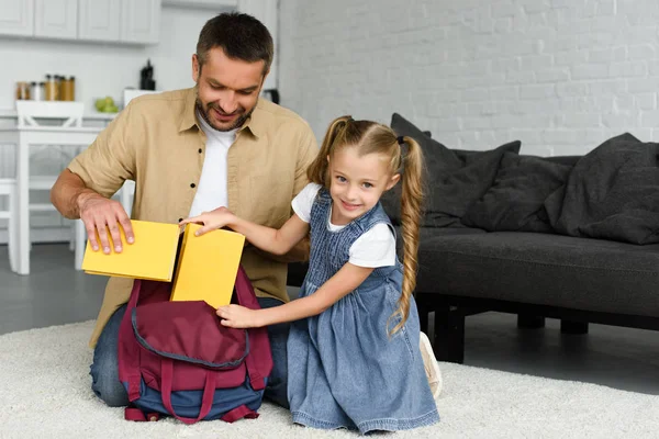 Sorrindo Pai Ajudando Filha Pequena Mochila Embalagem Para Primeiro Dia — Fotografia de Stock