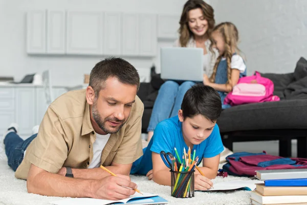 Selective Focus Father Son Doing Homework Together While Mother Daughter — Stock Photo, Image