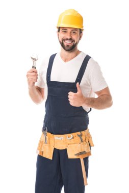 handsome happy workman holding wrench and smiling at camera isolated on white  clipart