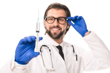 Medikal Ürünler üzerinde beyaz izole şırınga tutarak gülümseyen Doktor yakından görmek