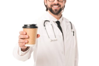 Beyaz önlük beyaz kağıt bardak kahve ile izole tutmak gülümseyen Doktor kırpılmış atış