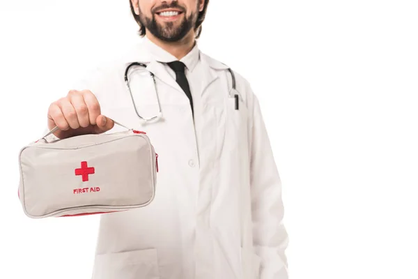 白で隔離応急処置キットを保持している笑顔の医者のクロップ撮影 — ストック写真