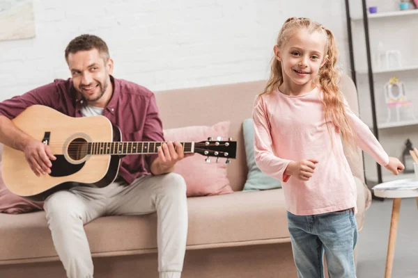 Gelukkige Dochter Dansen Terwijl Vader Spelen Gitaar — Gratis stockfoto