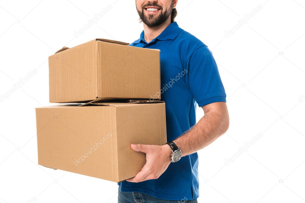 cropped shot of smiling delivery man holding cardboard boxes isolated on white