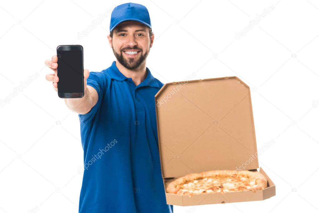 happy delivery man holding smartphone and pizza in box isolated on white  