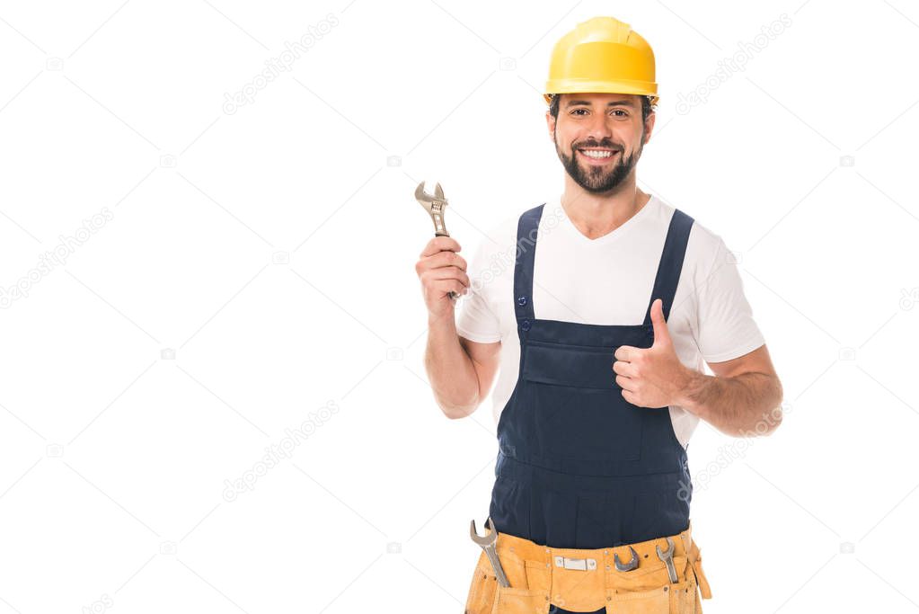 handsome happy workman holding wrench and showing thumb up isolated on white