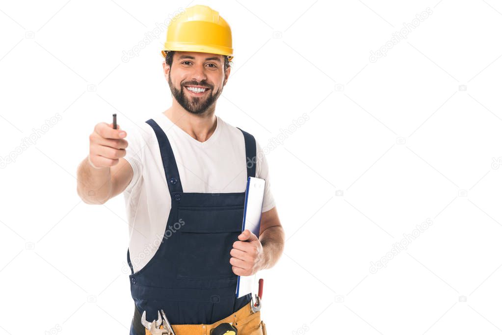 handsome construction worker in hard hat holding clipboard and smiling at camera isolated on white