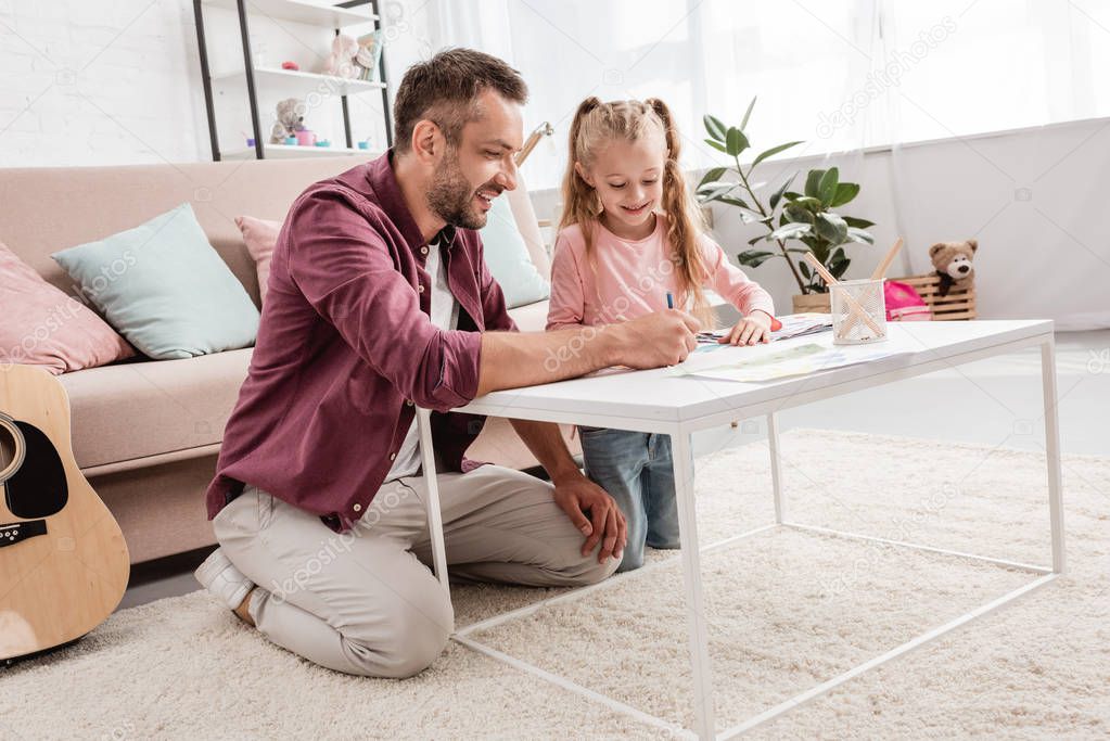 father and daughter having fun and drawing at home