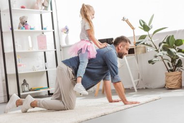 Baba arkasında oturan ve evde gülümseyen kızı