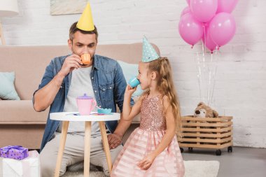 Baba ve çay partisi evde pembe balonlu oynayan kız