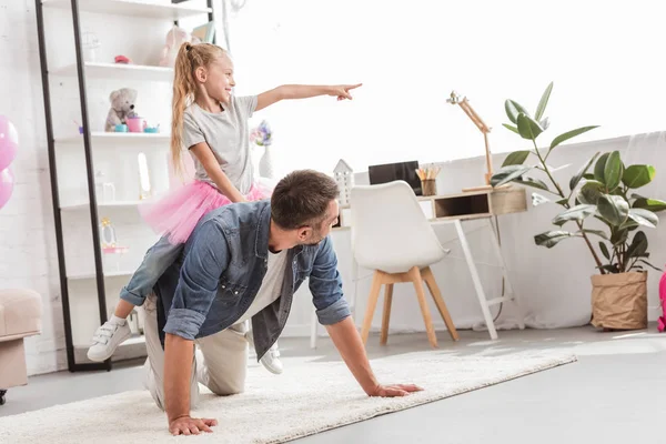 Hija Sentada Sobre Padre Espalda Mostrando Algo Ventana —  Fotos de Stock