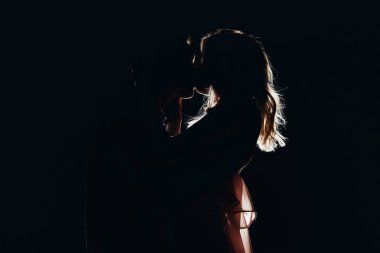 silhouettes of passionate couple kissing in dark clipart