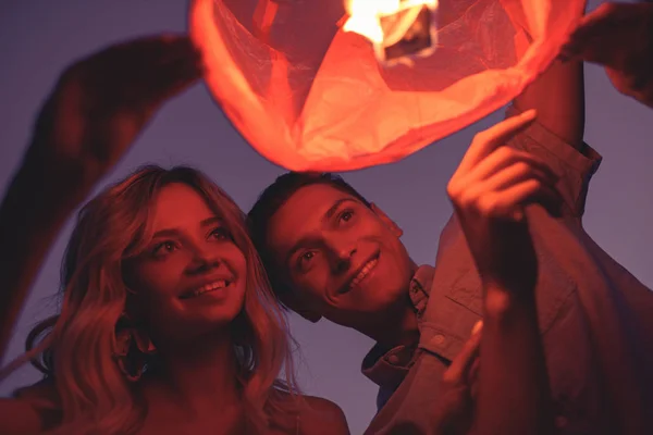 Friends Launching Sky Lantern River Beach Evening — Free Stock Photo