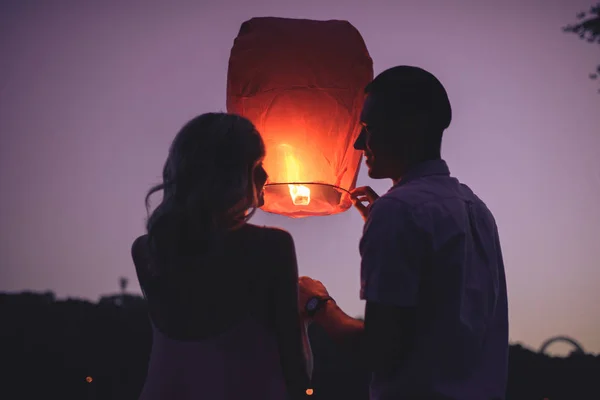 Silhouettes Couple Launching Sky Lantern River Beach Evening Looking Each — Stock Photo, Image