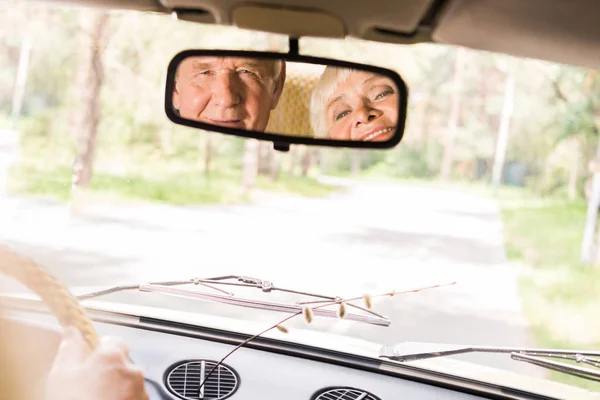 ビンテージ車の後部窓で幸せな先輩カップルのビュー — ストック写真