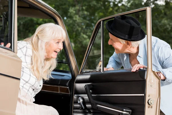 Sonriendo Hombre Mayor Abriendo Puerta Del Coche Delante Mujer — Foto de stock gratuita