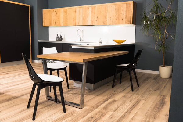 интерьер современной чистой светлой кухни с удобной мебелью и горшком
