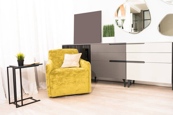 interior of bedroom with yellow armchair and mirrors