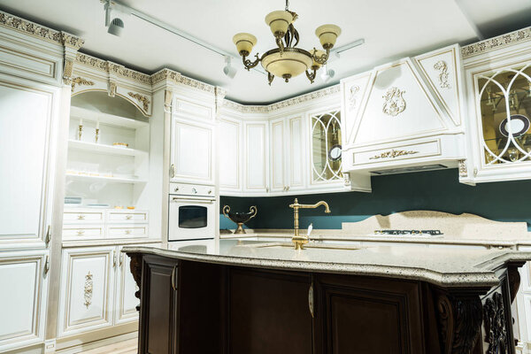 interior of modern white kitchen with comfortable wooden furniture in baroque style