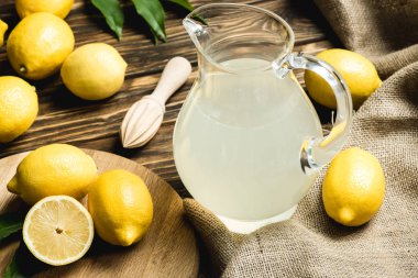 Cam sürahi taze meyve suyu, sıkacağı ve Sivas'tan Ahşap yüzeyi üzerinde sarı limon 