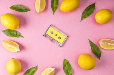 sarı limon ve vintage ses kaset içinde yapraklarla pembe üzerinde yapılan çerçevenin üstten görünüm