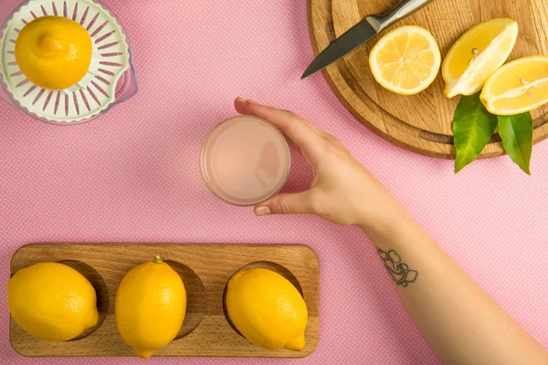 Верхний Вид Женской Руки Стаканом Лимонного Сока Розовом Столе Сжимателем — стоковое фото