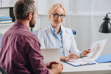 insan vücudu resmi hastane randevu sırasında hastaya gösterilen kadın chiropractor gülümseyen