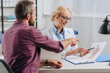 insan vücudu resmi hastane randevu sırasında hastaya gösterilen kadın chiropractor gülümseyen