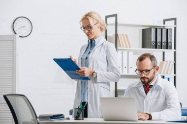 Fizyoterapistler beyaz ceket ve Gözlük Kliniği işyerinde portresi 