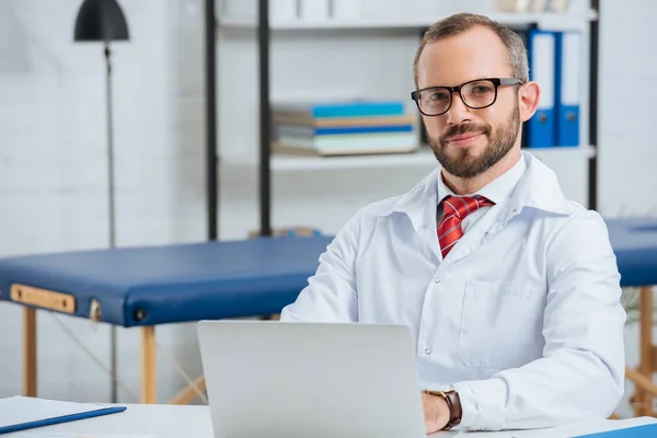 Portret Van Glimlachen Mannelijke Chiropractor Witte Jas Werkplek Met Laptop — Stockfoto