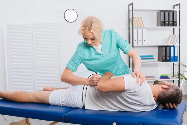 Fisioterapeuta Femenina Haciendo Masaje Paciente Mesa Masaje Hospital —  Fotos de Stock