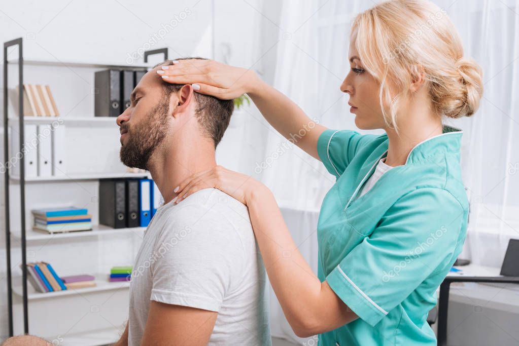 side view of female massage therapist doing neck massage to patient in clinic