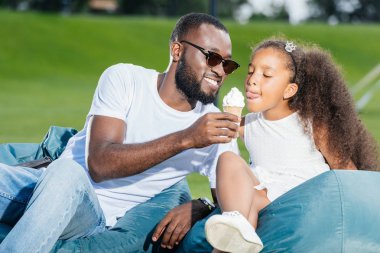 Afrikalı-Amerikalı babası kızı beanbag sandalye Park Tarih dondurma veren portresi