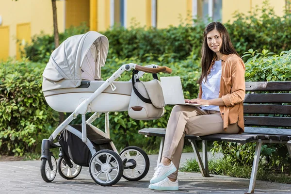 freelancer bebek arabası Park yakınındaki bankta laptop ile çalışma