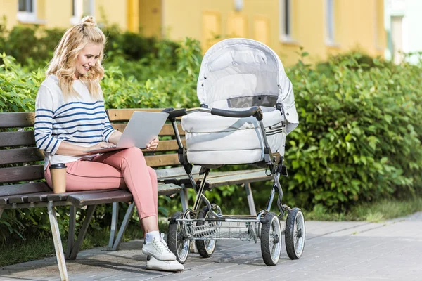 Glimlachend Freelancer Werken Met Laptop Bank Buurt Van Baby Wandelwagen — Stockfoto