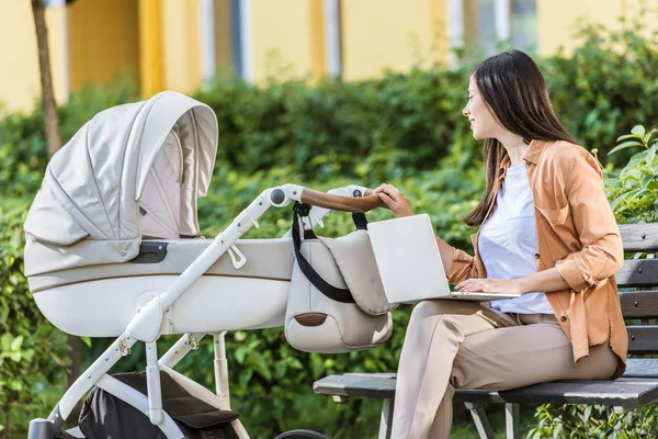 Freelancer Praca Laptopem Ławce Patrząc Wózek Dla Dzieci Parku — Zdjęcie stockowe