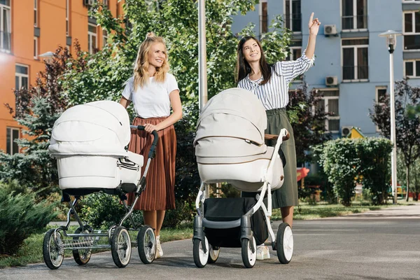 Mothers Walking Baby Strollers Street Woman Pointing Something Friend — Stock Photo, Image