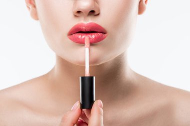 partial view of girl applying pink lip gloss,  isolated on white