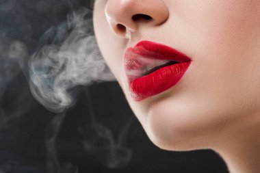 Kırmızı dudaklar duman üfleme ile kızın kırpılmış görünümü gri izole