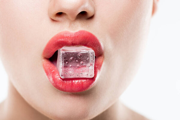 cropped view of woman holding ice cube in lips, isolated on white
